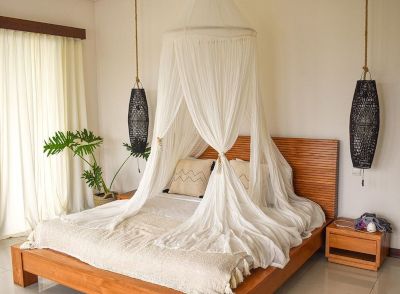 A wooden bed with mosquito net.