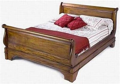 Tempat tidur gaya Jawa terbuat dari kayu gelap.